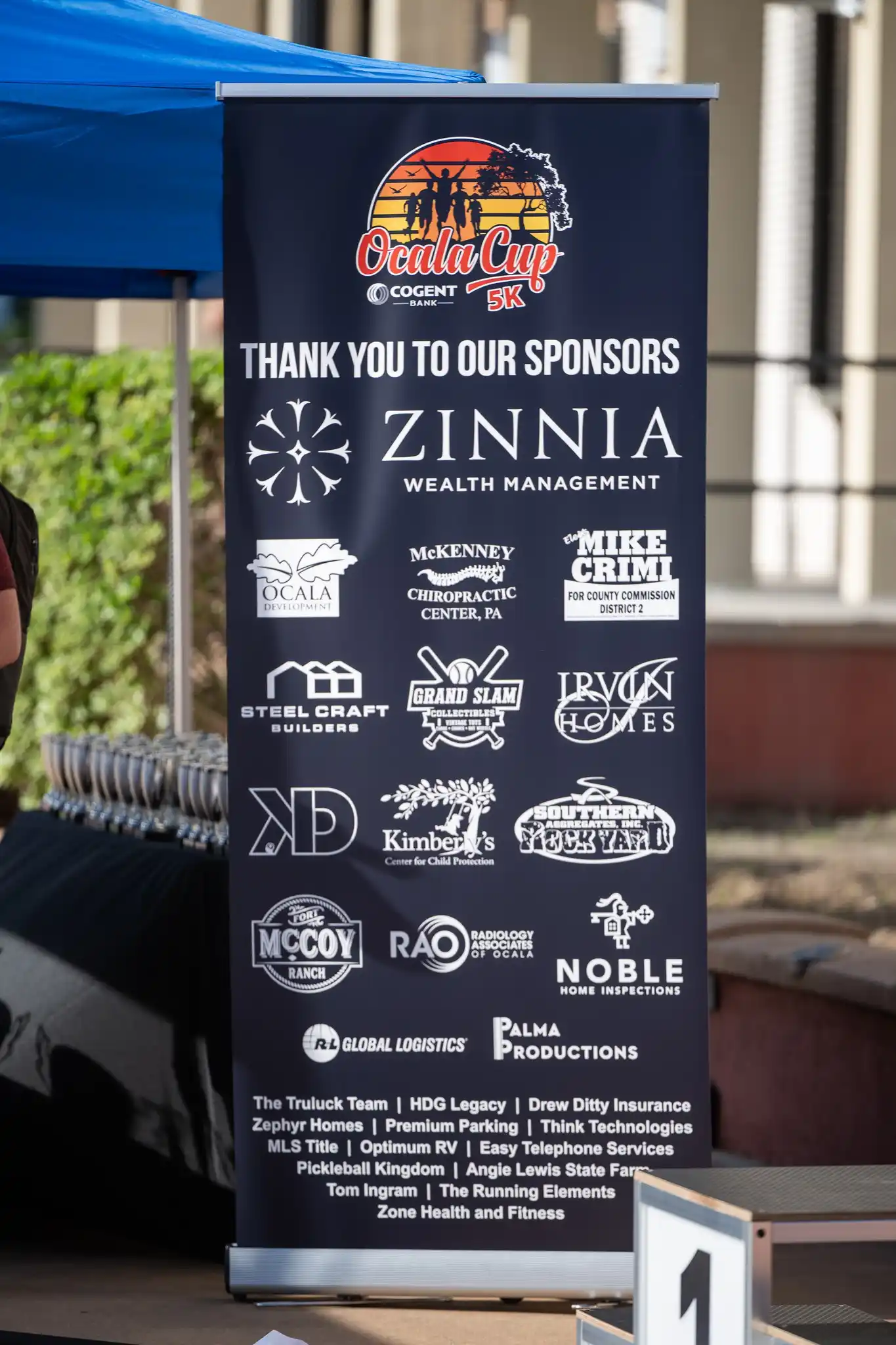 Ocala Cup 5K retractable pop-up banner — navy background with 'Thank You To Our Sponsors' headline and full sponsor logo grid